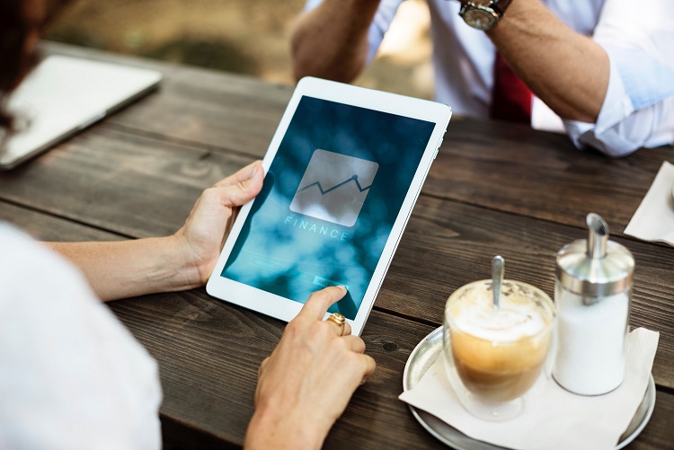 person holding ipad with coffee