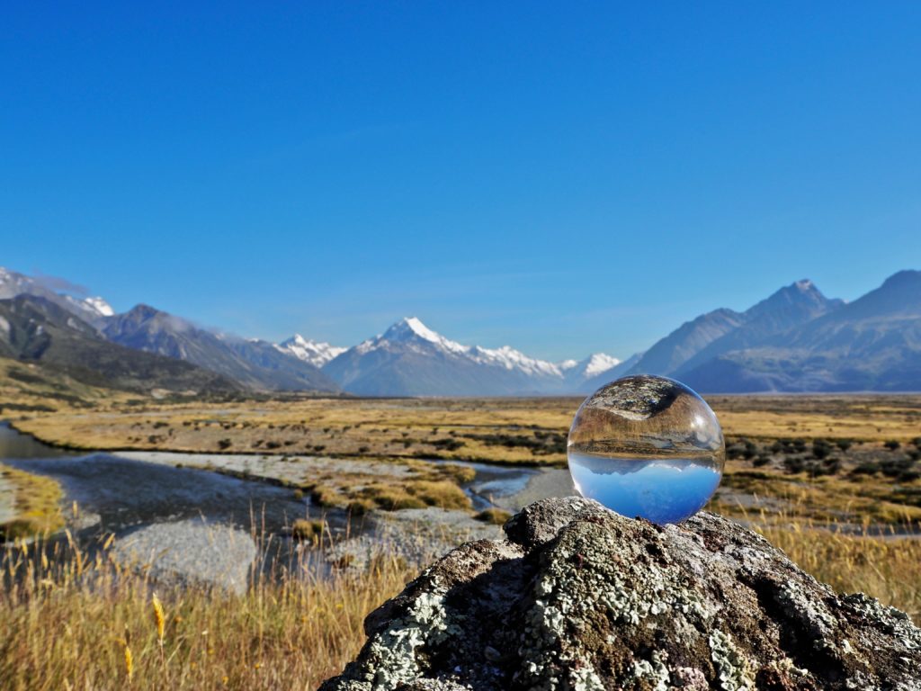 Mountain scene with globe magnifying the scene