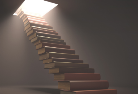 Staircase built of books with a light at the top